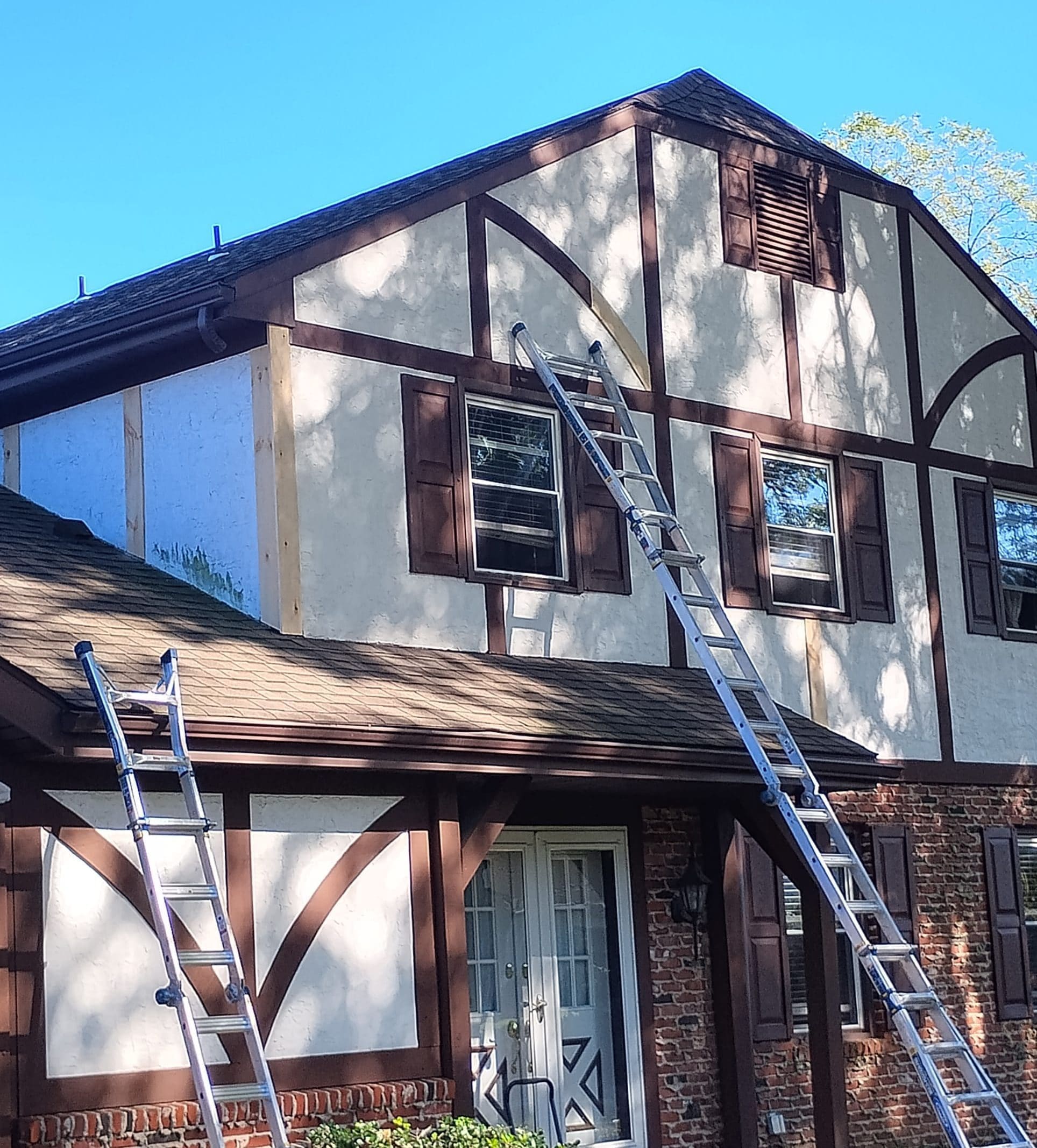 Two ladders leaning against a house.